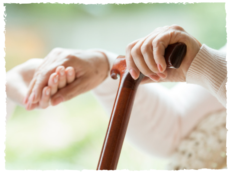Senioren hält einen Gehstock und eine stützende Hand